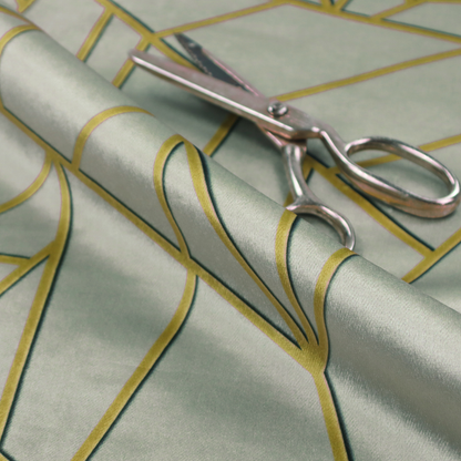 A close-up of a luxurious silver fabric featuring a fractured, geometric mosaic pattern. The soft, matte background is segmented by a network of recessed metallic gold lines that form sharp, irregular polygons. This "shattered-glass" effect creates a calm yet architectural look, blending cool, desaturated tones with shimmering, Art Deco-inspired gold linework for a high-end, contemporary finish.