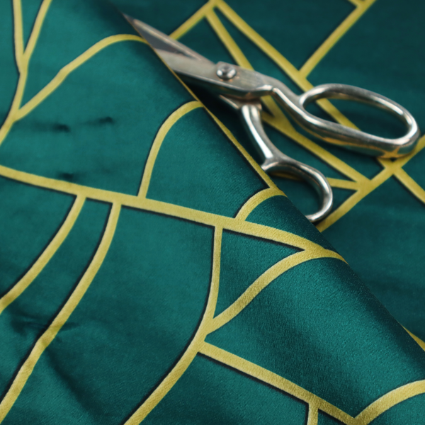 A close-up of a luxurious deep peacock or dark teal fabric featuring a fractured, geometric mosaic pattern. The moody, matte background is segmented by a network of recessed metallic gold lines that form sharp, irregular polygons. This "shattered-glass" effect pairs a sophisticated, dark jewel-toned base with shimmering, Art Deco-inspired gold accents for a dramatic and architectural look.