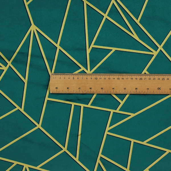 A close-up of a luxurious deep peacock or dark teal fabric featuring a fractured, geometric mosaic pattern. The moody, matte background is segmented by a network of recessed metallic gold lines that form sharp, irregular polygons. This "shattered-glass" effect pairs a sophisticated, dark jewel-toned base with shimmering, Art Deco-inspired gold accents for a dramatic and architectural look.