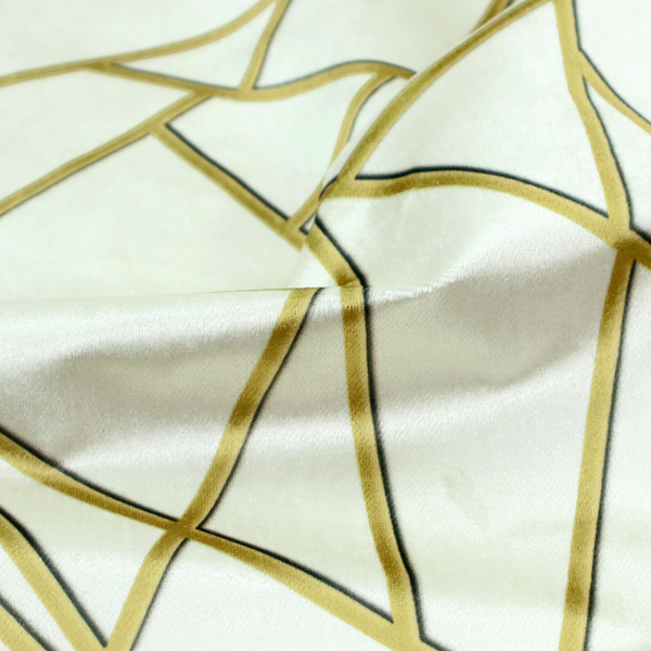 A close-up of a luxurious stark white or ivory fabric featuring a fractured, geometric mosaic pattern. The clean, matte background is segmented by a network of recessed metallic gold lines that form sharp, irregular polygons. This "shattered-glass" effect creates a sophisticated architectural look, pairing a bright, neutral base with shimmering, Art Deco-inspired gold linework for a high-contrast and contemporary finish.