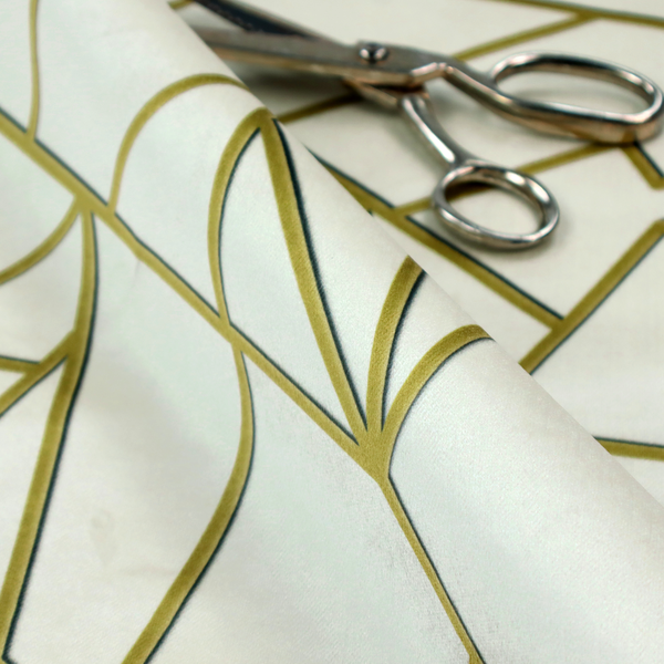 A close-up of a luxurious stark white or ivory fabric featuring a fractured, geometric mosaic pattern. The clean, matte background is segmented by a network of recessed metallic gold lines that form sharp, irregular polygons. This "shattered-glass" effect creates a sophisticated architectural look, pairing a bright, neutral base with shimmering, Art Deco-inspired gold linework for a high-contrast and contemporary finish.