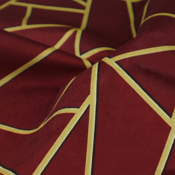 A close-up of a luxurious burgundy or wine red fabric featuring a fractured, geometric mosaic pattern. The dark, velvety matte background is segmented by a network of recessed metallic gold lines that form sharp, irregular polygons. This "shattered-glass" effect pairs a rich, deep-toned base with shimmering, Art Deco-inspired gold linework for a dramatic and architectural look.