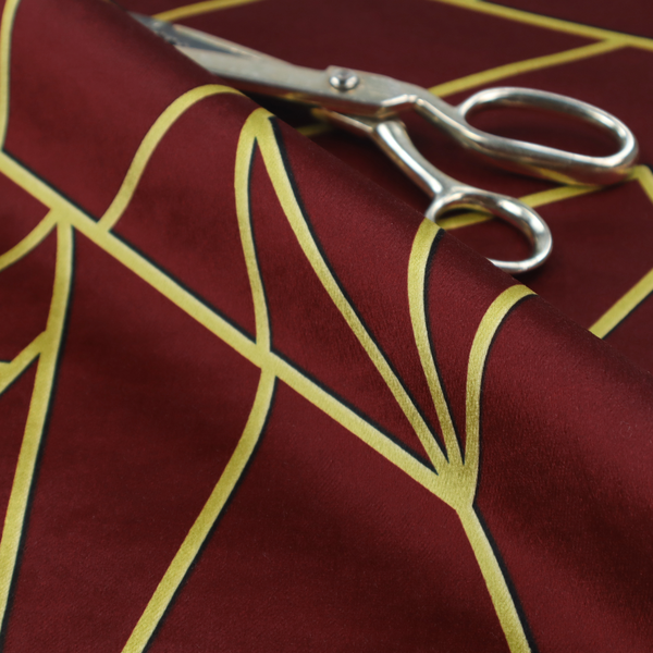 A close-up of a luxurious burgundy or wine red fabric featuring a fractured, geometric mosaic pattern. The dark, velvety matte background is segmented by a network of recessed metallic gold lines that form sharp, irregular polygons. This "shattered-glass" effect pairs a rich, deep-toned base with shimmering, Art Deco-inspired gold linework for a dramatic and architectural look.