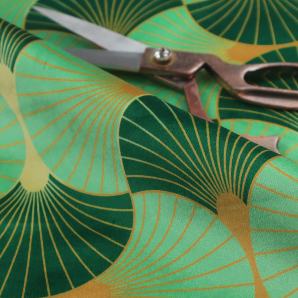 The DP-383-1 fabric features a sophisticated Art Deco design characterized by an interlocking scalloped fan motif that creates a rhythmic, geometric aesthetic. The pattern utilizes a balanced, tri-colour palette consisting of deep forest green for structured contrast, soft sage for a fresh and contemporary feel, and bright ochre to highlight the radiating lines and focal points.