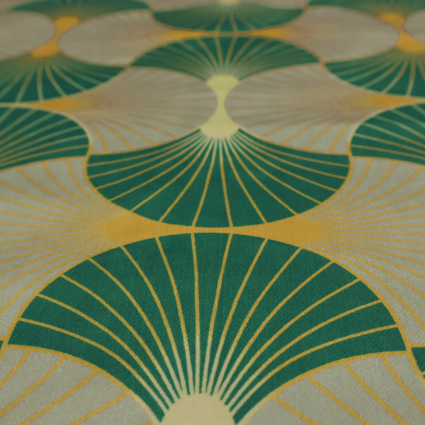 The DP-385-1 fabric presents a sophisticated Art Deco aesthetic featuring an interlocking scalloped fan motif that creates a rhythmic, architectural symmetry across the textile. This specific variation utilizes a refined colour palette of deep emerald green, cool slate grey, and warm ochre. The pattern is composed of alternating shells where thin lines radiate from golden central points, set against a subtle cream background that peeks through at the base of each fan.