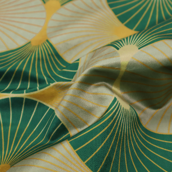 The DP-385-1 fabric presents a sophisticated Art Deco aesthetic featuring an interlocking scalloped fan motif that creates a rhythmic, architectural symmetry across the textile. This specific variation utilizes a refined colour palette of deep emerald green, cool slate grey, and warm ochre. The pattern is composed of alternating shells where thin lines radiate from golden central points, set against a subtle cream background that peeks through at the base of each fan.