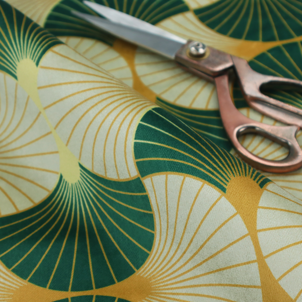 This fabric features a cohesive Art Deco-inspired print, showcasing a rhythmic, interlocking scalloped fan motif that evokes the architectural elegance of the 1920s. Each variation uses a "fish scale" layout with thin lines radiating from golden-orange focal points, but offers a distinct mood through its specific colour story.