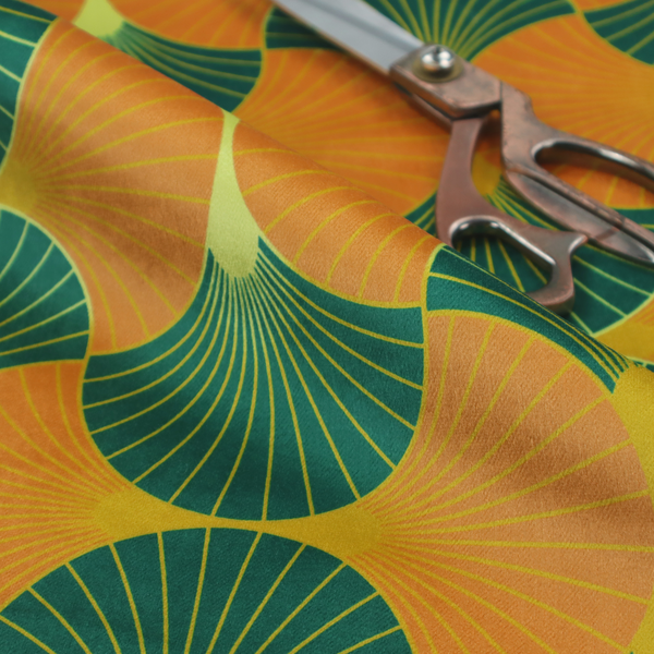 The DP-397-1 fabric showcases a vibrant and warm Art Deco aesthetic, featuring a rhythmic, interlocking scalloped fan motif in a "fish scale" arrangement. This specific colourway utilizes a bold, high-contrast palette of deep forest green and saturated orange fans.