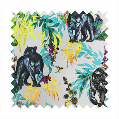 A vibrant tropical fabric print featuring sleek black panthers prowling among exotic flora. The design includes colourful botanical elements like oversized teal and lime green leaves, magenta flowers, and yellow ferns. Small details like a soaring owl and a hummingbird are scattered throughout on a pale grey background.