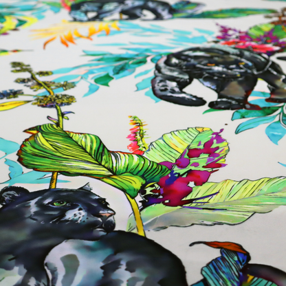A vibrant tropical fabric print featuring sleek black panthers prowling among exotic flora. The design includes colourful botanical elements like oversized teal and lime green leaves, magenta flowers, and yellow ferns. Small details like a soaring owl and a hummingbird are scattered throughout on a pale grey background.