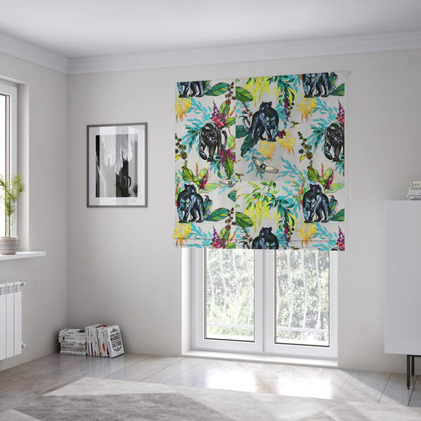 The fabric used to create these Roman blinds is a vibrant tropical fabric print featuring sleek black panthers prowling among exotic flora. The design includes colourful botanical elements like oversized teal and lime green leaves, magenta flowers, and yellow ferns. Small details like a soaring owl and a hummingbird are scattered throughout on a pale grey background.