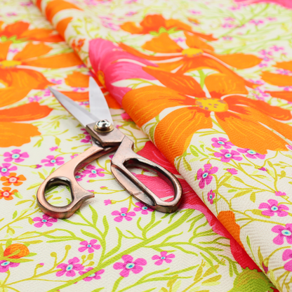 This fabric features a dense, vibrant botanical and floral pattern with a retro, meadow-like feel.