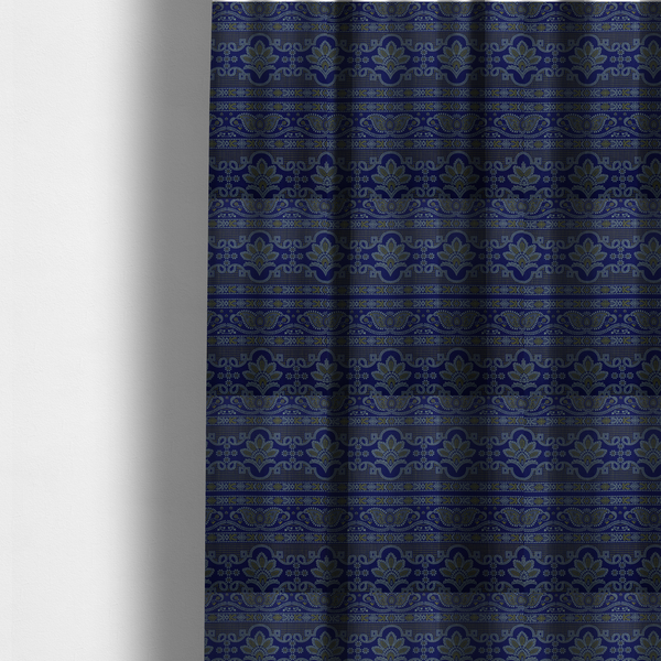 The fabric used to create these made-to-measure curtains has an intricate royal blue and yellow fabric featuring traditional ornate damask and paisley motifs arranged in horizontal decorative bands.