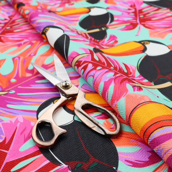 This fabric features vibrant, tropical-themed repeating pattern showcasing toucans and exotic foliage.