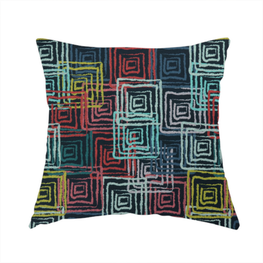 The fabric used to create this handmade cushion is an abstract geometric pattern featuring overlapping nested squares in vibrant shades of red, teal, yellow, and grey on a dark background.