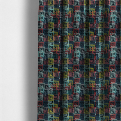 The fabric used to create these made-to-measure curtains is an abstract geometric pattern featuring overlapping nested squares in vibrant shades of red, teal, yellow, and grey on a dark background.