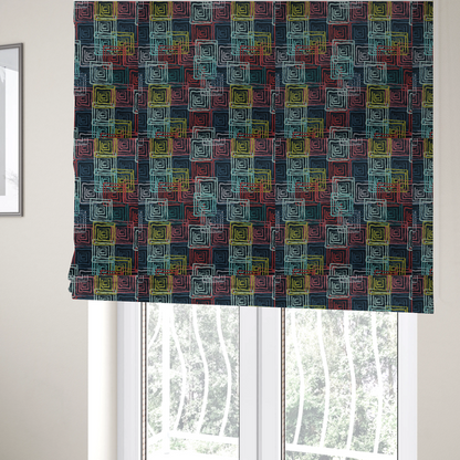 The fabric used to create these Roman blinds is an abstract geometric pattern featuring overlapping nested squares in vibrant shades of red, teal, yellow, and grey on a dark background.