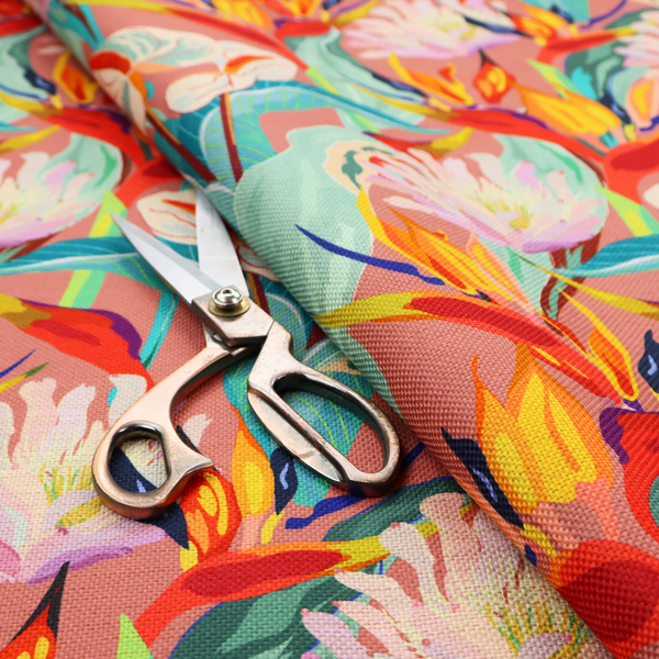 Vibrant repeating botanical pattern featuring tropical flowers, including birds of paradise and white anthuriums, with large green leaves against a dusty pink background.