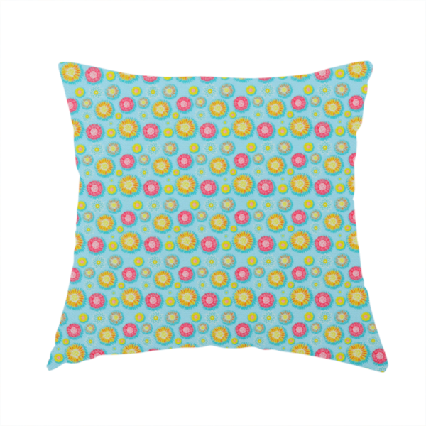 The fabric used to create this handmade cushion is a light blue fabric featuring an all-over repeating pattern of vibrant pink and gold floral motifs interspersed with small yellow dotted accents.