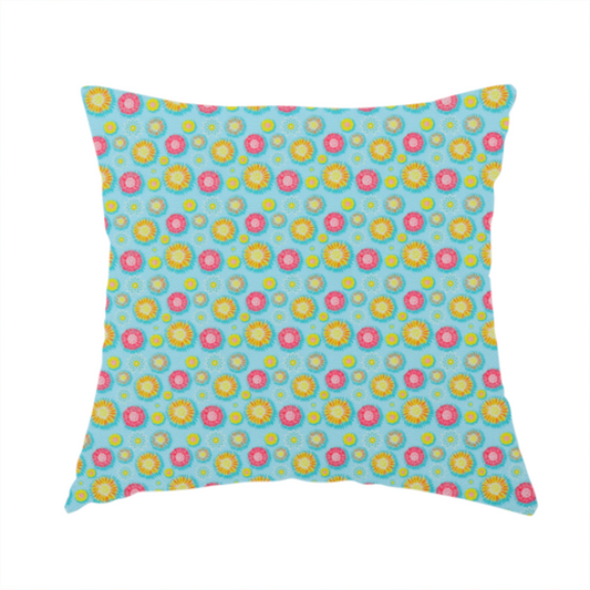 The fabric used to create this handmade cushion is a light blue fabric featuring an all-over repeating pattern of vibrant pink and gold floral motifs interspersed with small yellow dotted accents.