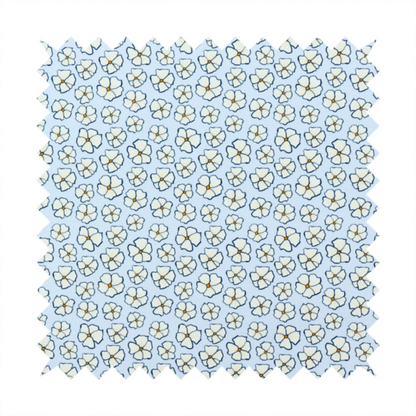 A light blue fabric featuring a dense, repeating pattern of small white flowers with yellow centres and dark outlines.