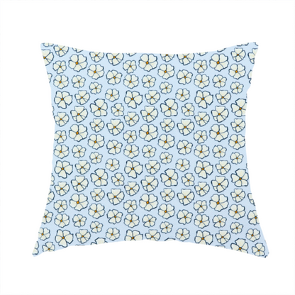 The fabric used to create this handmade cushion is a light blue fabric featuring a dense, repeating pattern of small white flowers with yellow centres and dark outlines.