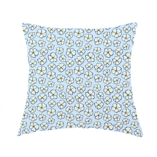 The fabric used to create this handmade cushion is a light blue fabric featuring a dense, repeating pattern of small white flowers with yellow centres and dark outlines.