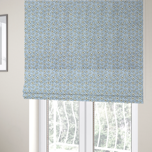 The fabric used to create these Roman blinds is a light blue fabric featuring a dense, repeating pattern of small white flowers with yellow centres and dark outlines.