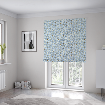 The fabric used to create these Roman blinds is a light blue fabric featuring a dense, repeating pattern of small white flowers with yellow centres and dark outlines.
