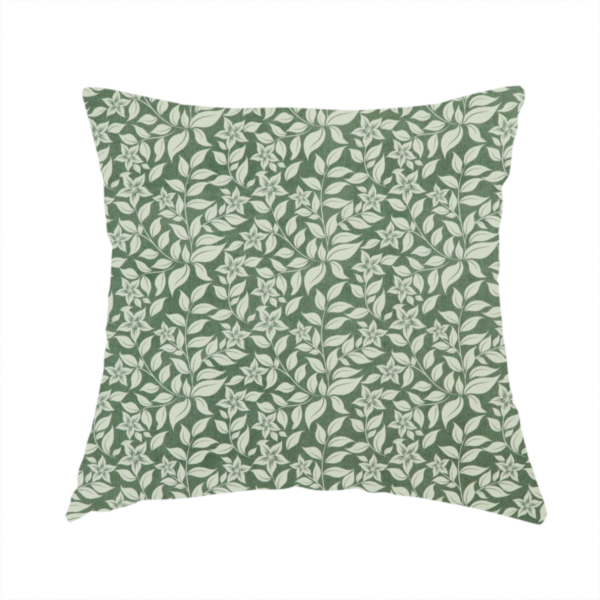 The fabric used to create this handmade cushion is a green fabric featuring an intricate, repeating botanical pattern of trailing vines, leaves, and small white flowers.