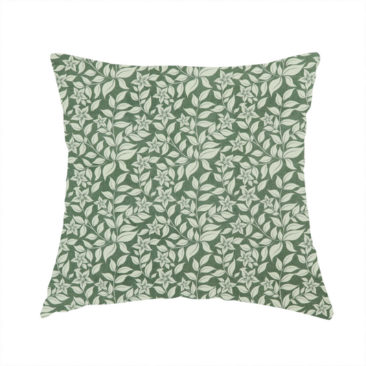 The fabric used to create this handmade cushion is a green fabric featuring an intricate, repeating botanical pattern of trailing vines, leaves, and small white flowers.