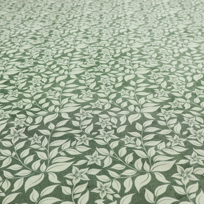 A green fabric featuring an intricate, repeating botanical pattern of trailing vines, leaves, and small white flowers.