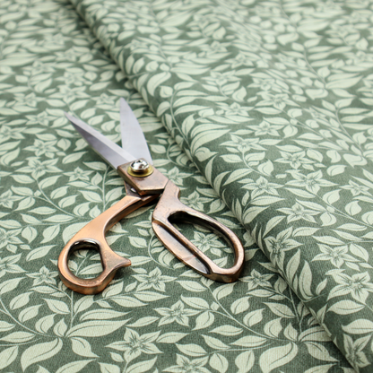 A green fabric featuring an intricate, repeating botanical pattern of trailing vines, leaves, and small white flowers.