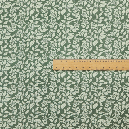 A green fabric featuring an intricate, repeating botanical pattern of trailing vines, leaves, and small white flowers.