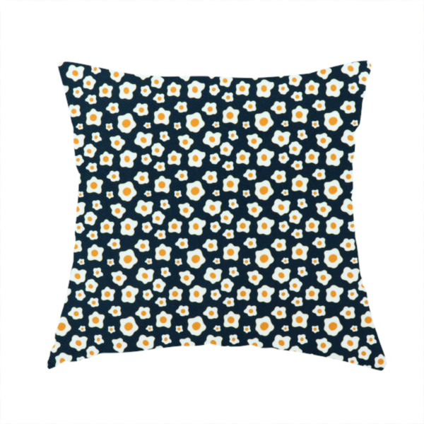 The fabric used to create this handmade cushion is a dark navy blue fabric featuring a dense, repeating pattern of small fried egg motifs with white whites and yellow yolks.