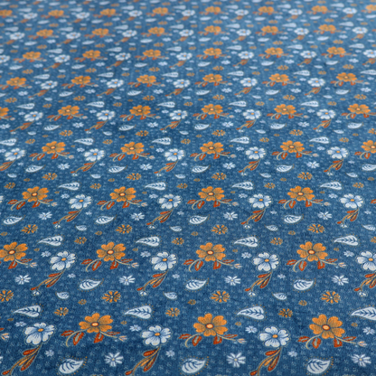 A royal blue fabric featuring a detailed, repeating pattern of orange and white flowers, small leaves, and sprigs