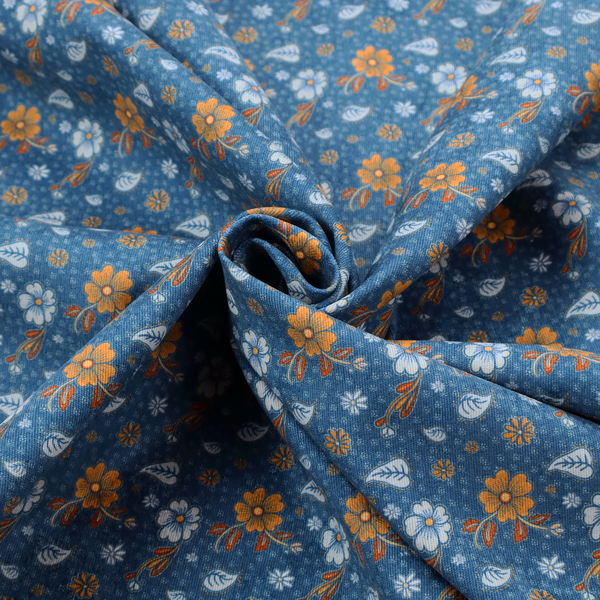 A royal blue fabric featuring a detailed, repeating pattern of orange and white flowers, small leaves, and sprigs