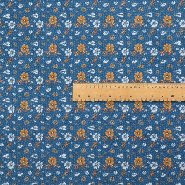 A royal blue fabric featuring a detailed, repeating pattern of orange and white flowers, small leaves, and sprigs
