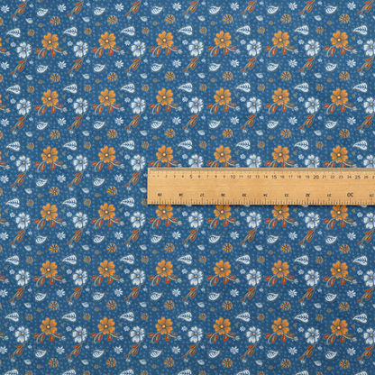 A royal blue fabric featuring a detailed, repeating pattern of orange and white flowers, small leaves, and sprigs