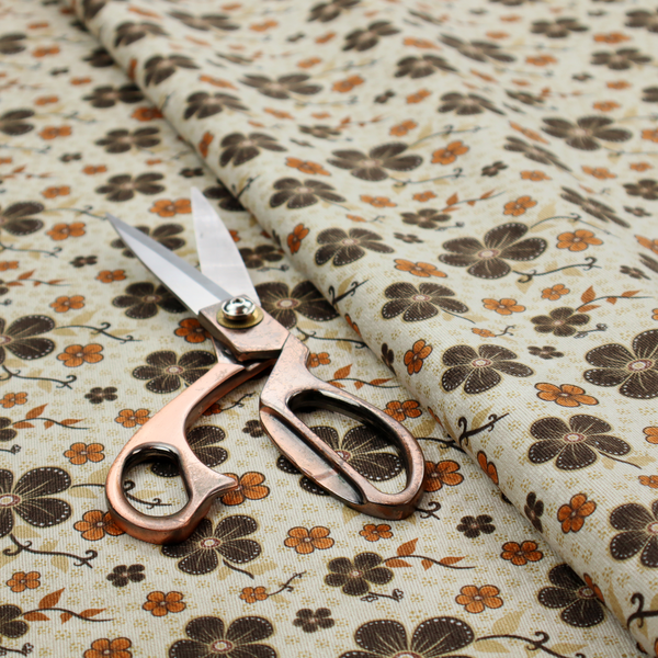 A light cream fabric featuring a repeating retro pattern of dark brown and orange flowers with scrolling vines.