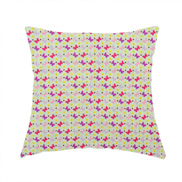 The fabric used to create this handmade cushion is a light green fabric featuring a dense, repeating pattern of small multi-coloured butterflies in pink, magenta, and purple, interspersed with tiny yellow flowers and dots.