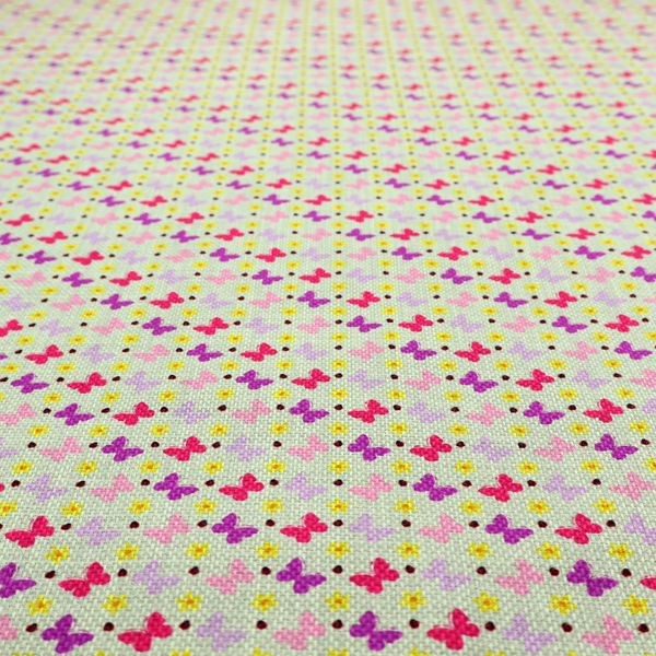A light green fabric featuring a dense, repeating pattern of small multi-coloured butterflies in pink, magenta, and purple, interspersed with tiny yellow flowers and dots.