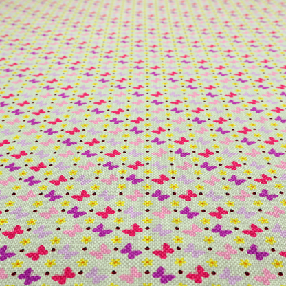 A light green fabric featuring a dense, repeating pattern of small multi-coloured butterflies in pink, magenta, and purple, interspersed with tiny yellow flowers and dots.