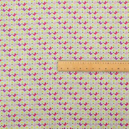 A light green fabric featuring a dense, repeating pattern of small multi-coloured butterflies in pink, magenta, and purple, interspersed with tiny yellow flowers and dots.