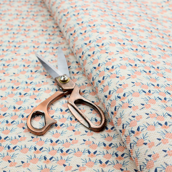 An off-white fabric featuring a neat, repeating geometric pattern of small peach-pink flowers and dark blue leafy sprigs.