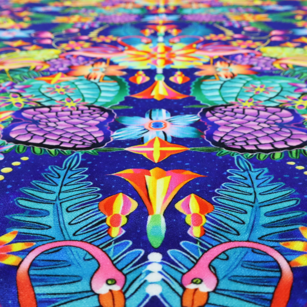 This fabric features an intricate, psychedelic-inspired tropical print with a rich, dark blue background.