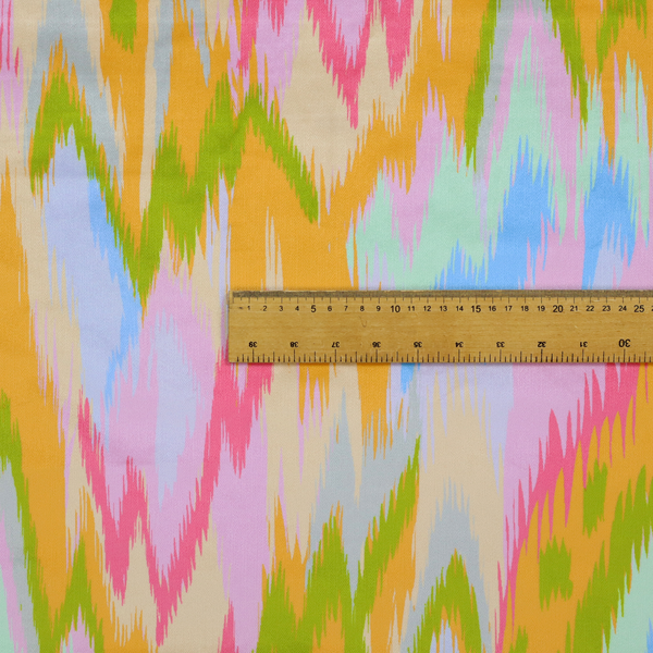 This fabric features a vibrant, multi-coloured ikat-style pattern with a soft, blurred aesthetic.