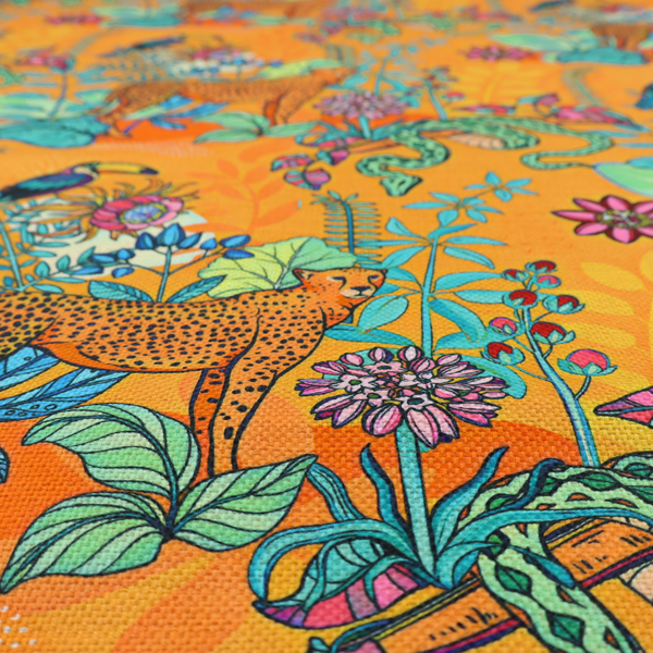 This vibrant, maximalist fabric features a stylized jungle motif set against a bold, warm orange background.