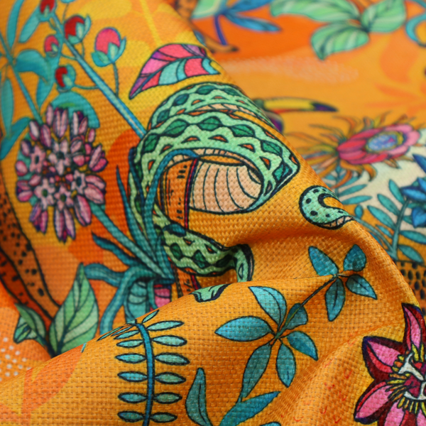 This vibrant, maximalist fabric features a stylized jungle motif set against a bold, warm orange background.