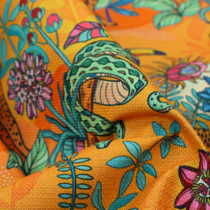 This vibrant, maximalist fabric features a stylized jungle motif set against a bold, warm orange background.